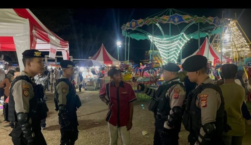 Bripka Josnardi (Baret Biru) berbincang -bincang dengan masyarakat. Arena Pasar Malam, Trienggadeng, pada malam Rabu (29/1/2025). Foto/Ms.