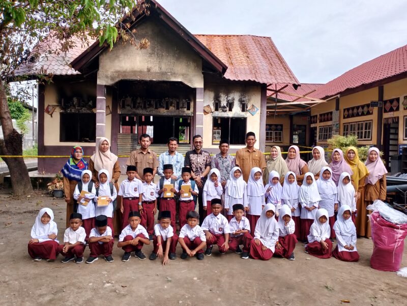 Wakil Ketua DPRK Pidie Jaya, Kevin Fahlevi ( baju Hitam) ,dan Azrizal Syahputra (kanan Kevin) foto bersama dewan guru dan murid SDN 2 Meureudu, Senin ( 28/4/2025).Foto: Dok/Muhammad Rissan 