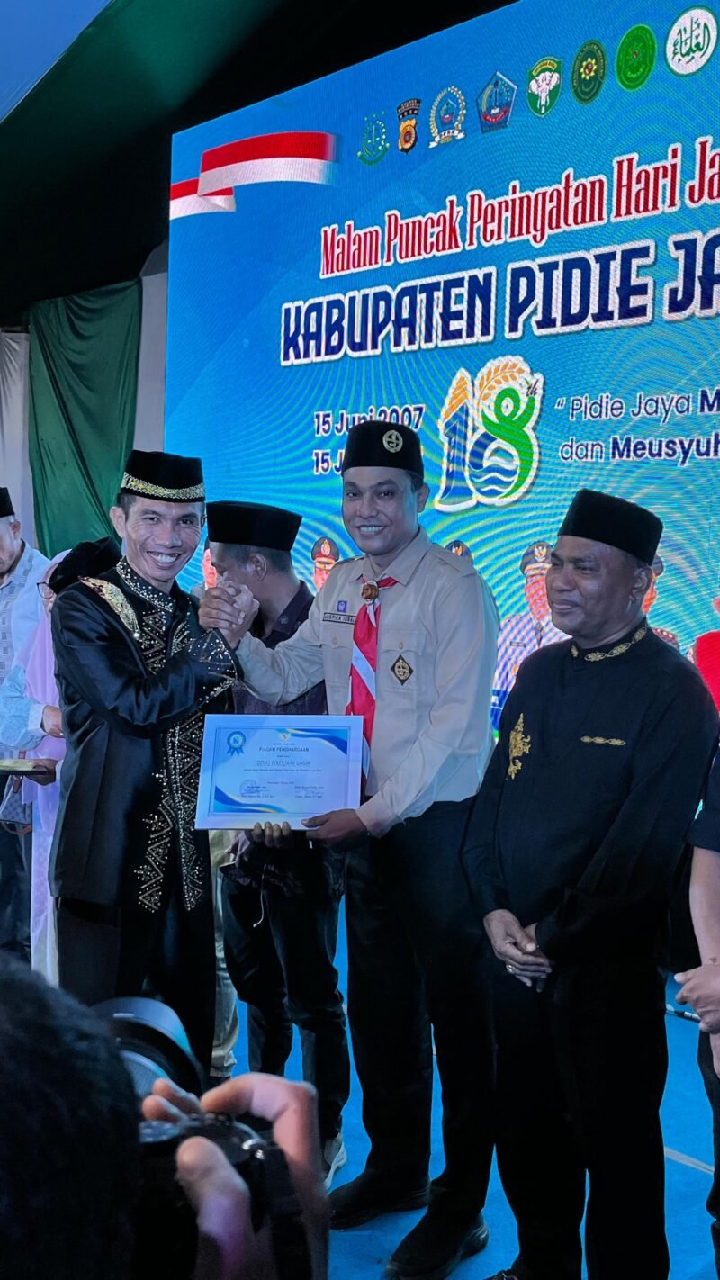 Dandim 0102 Pidie -Pidie Jaya Letkol Andi Irsan, M.Han salam Komando dengan Pengurus Kwarcab Gerakan Pramuka Pidie Jaya Mustika Iqbal , di acara penyerahan penghargaan kepada Organisasi / Lembaga pendukung Pemerintah, Lapangan Bola Kaki Kota Meureudu, Minggu Malam (15/6/2025).Foto:Dok/Humas Kwarcab Pramuka Pidie Jaya 