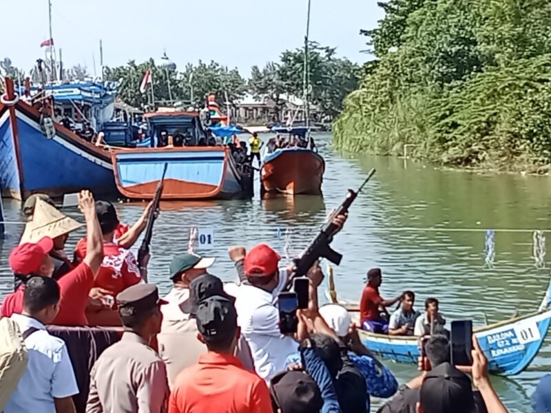 Bupati Pidie Jaya Tgk. H. Syibral Malasyi MA., S. Sos., ME ( baju merah nampak belakang dengan senjata Laras pajang ) dan Wakil Bupati Pidie Jaya Hasan Basri, ST. MM ( Baju Putih dengan memenangkan senjata Laras panjang ) bersiap siap melakukan tembakan ke atas tanda perlombaan di mulai. Krueng Meureudu, Minggu (17/8/2025). Foto:Dok/Muhammad Rissan 