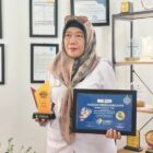 Kepala Puskesmas Darul Kamal, Maya Sopa, menunjukkan dokumen kerja sama publikasi internasional bersama UNICEF di Darul Kamal, Aceh Besar, Rabu (15/04/2026).