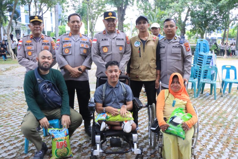 Wakapolda Aceh Ari Wahyu Widodo berfoto bersama warga usai penyaluran bantuan beras pada peringatan May Day 2026 di Banda Aceh, Jumat (1/5/2026). Foto: (Humas Polda Aceh).
