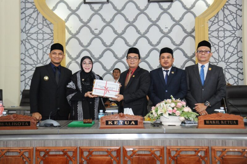 Wali Kota Banda Aceh Illiza Sa’aduddin Djamal menyerahkan dokumen LKPJ Tahun Anggaran 2025 kepada Ketua DPRK Banda Aceh Irwansyah, ST, dalam rapat paripurna di Gedung DPRK Banda Aceh, Senin (13/7/2026). Foto: Dok. DPRK Banda Aceh