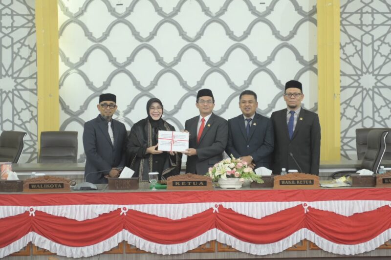 Ketua DPRK Banda Aceh Irwansyah, ST menerima dokumen kesepakatan RKUA-PPAS APBK Banda Aceh 2027 bersama Wali Kota Banda Aceh Illiza Sa’aduddin Djamal beserta Jajaran dalam sidang paripurna, Jumat (14/8/2026). Foto: Dok. DPRK Banda Aceh